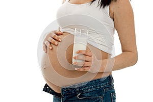 Studio portrait of pregnant woman with glasses of milk in her hands isolated on white background