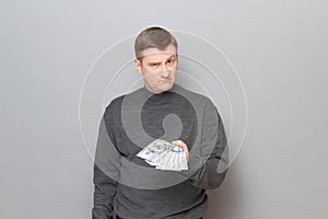 Portrait of proud confident man stretching out his hand with money