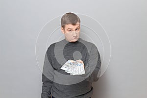 Portrait of proud confident man stretching out his hand with money