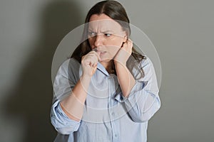 Studio portrait of scared woman biting her nails