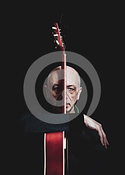 Studio portrait of senior man with guitar