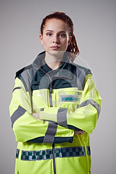 Studio Portrait Of Serious Young Female Paramedic Against Plain Background