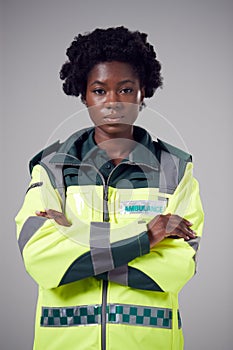 Studio Portrait Of Serious Young Female Paramedic Against Plain Background