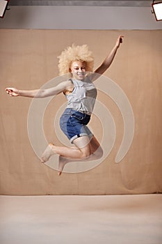 Studio Portrait Shot Of Body Positive Albino Woman Jumping In The Air