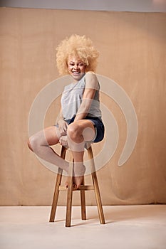 Studio Portrait Shot Of Body Positive Albino Woman Sitting On Stool