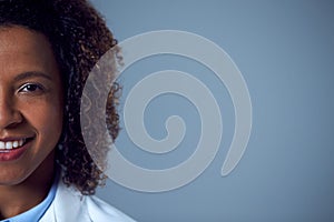 Studio Portrait Of Smiling Female Doctor Or Lab Worker In White Coat
