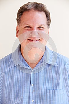 Studio Portrait Of Smiling Overweight Man