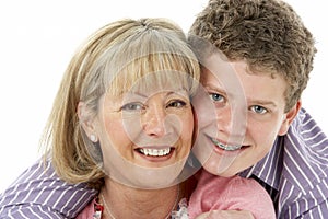 Studio Portrait of Smiling Teenage Boy with Mum