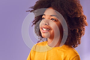 Studio Portrait Of Smiling Young Boy Shot Against Purple Background