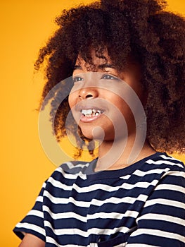 Studio Portrait Of Smiling Young Boy Shot Against Yellow Background