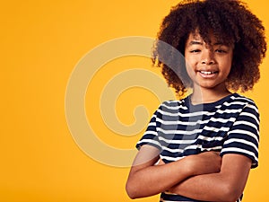 Studio Portrait Of Smiling Young Boy Shot Against Yellow Background