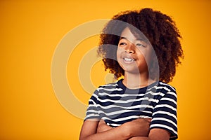 Studio Portrait Of Smiling Young Boy Shot Against Yellow Background