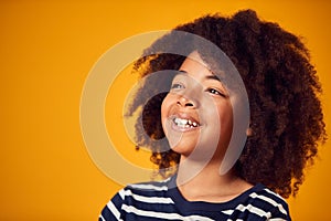 Studio Portrait Of Smiling Young Boy Shot Against Yellow Background