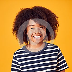 Studio Portrait Of Smiling Young Boy Shot Against Yellow Background