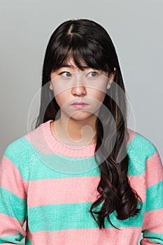Studio portrait of a teenage East Asian woman looking sideways