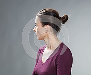 Studio portrait of a thinking 30s woman, profile view