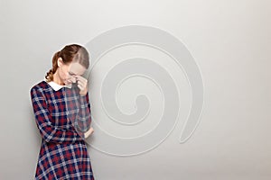 Portrait of thoughtful tired girl touching bridge of nose with hand