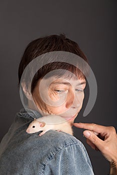 Studio portrait of woman with baby rat