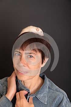 Studio portrait of woman with white baby rat