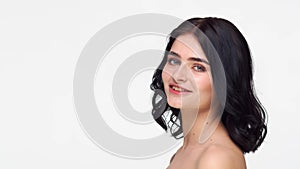 Studio portrait of young and beautiful brunette woman over isolated white background. Skin care, health, makeup and