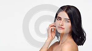 Studio portrait of young and beautiful brunette woman over isolated white background. Skin care, health, makeup and