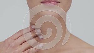 Studio portrait of young, beautiful and natural blond woman applying skin care cream. Face lifting, cosmetics and make