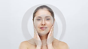 Studio portrait of young, beautiful and natural blond woman applying skin care cream. Face lifting, cosmetics and make