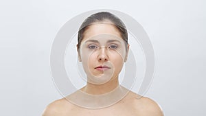 Studio portrait of young, beautiful and natural blond woman applying skin care cream. Face lifting, cosmetics and make