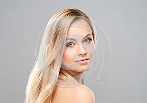 Studio portrait of young, beautiful and natural blond woman over grey background. Face lifting, plastic surgery