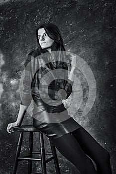 Studio portrait of young beautiful woman in a leather skirt