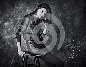 Studio portrait of young beautiful woman in a leather skirt