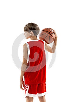 Studio portrait of young boy, basketball player in red uniform posing isolated over white background. Back view