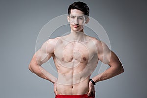 Studio portrait of a young brunette caucasian man on gray background posing. Puberty theme, problem skin, teen acne