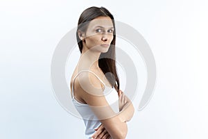 Studio portrait of young Caucasian woman with serious upset dissatisfied with a puzzled expression. arms crossed over the abdomen.