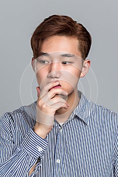 Studio portrait of a young East Asian man in distress