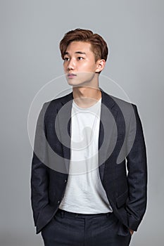 Studio portrait of a young East Asian man looking up