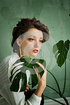 Estudio retrato joven moda agotador blanco un suéter sobre el verde a exótico plantas 