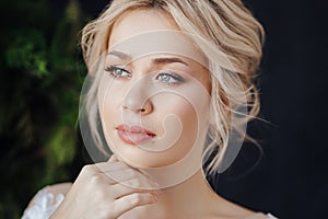 Studio portrait of a young girl of the bride with professional wedding makeup.