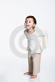 Studio portrait of a young girl hiding something and making fun of an opponent