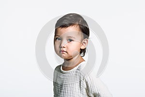 Studio portrait of a young girl staring at camera with sad eyes