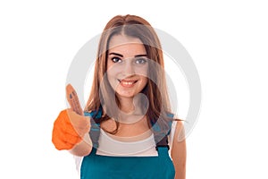 Studio portrait of young happy girl in uniform makes renavation and showing thumbs up isolated on white background