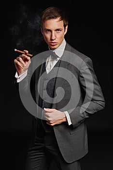 Studio portrait of young man smoking a cigar