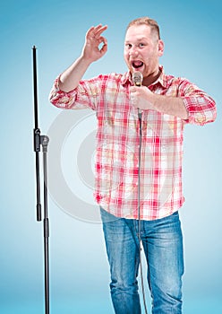 Studio portrait of a young showman with the microphone