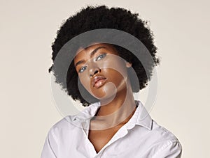 Studio portrait of a young stunning African American woman with a beautiful afro. Confident black female model showing