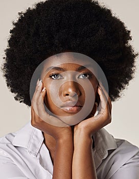 Studio portrait of a young stunning African American woman with a beautiful afro. Confident black female model showing