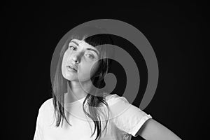 Studio portrait of a young woman against plain black background