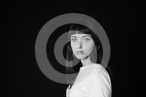 Studio portrait of a young woman against plain black background