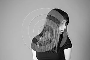 Studio portrait of a young woman against plain black background