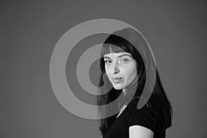 Studio portrait of a young woman against plain black background