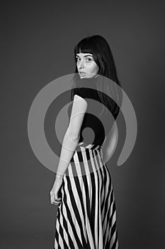 Studio portrait of a young woman against plain black background